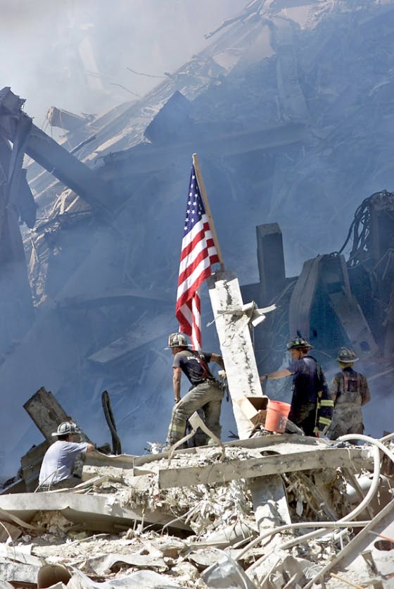 An FDNY firefighter raises the American flag on the Ground Zero pile in the days after the 9/11 attacks.
