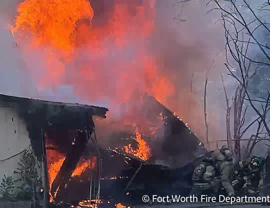 Fort Worth firefighters work to free an injured colleague after a garage roof collapsed during a fire Wednesday.