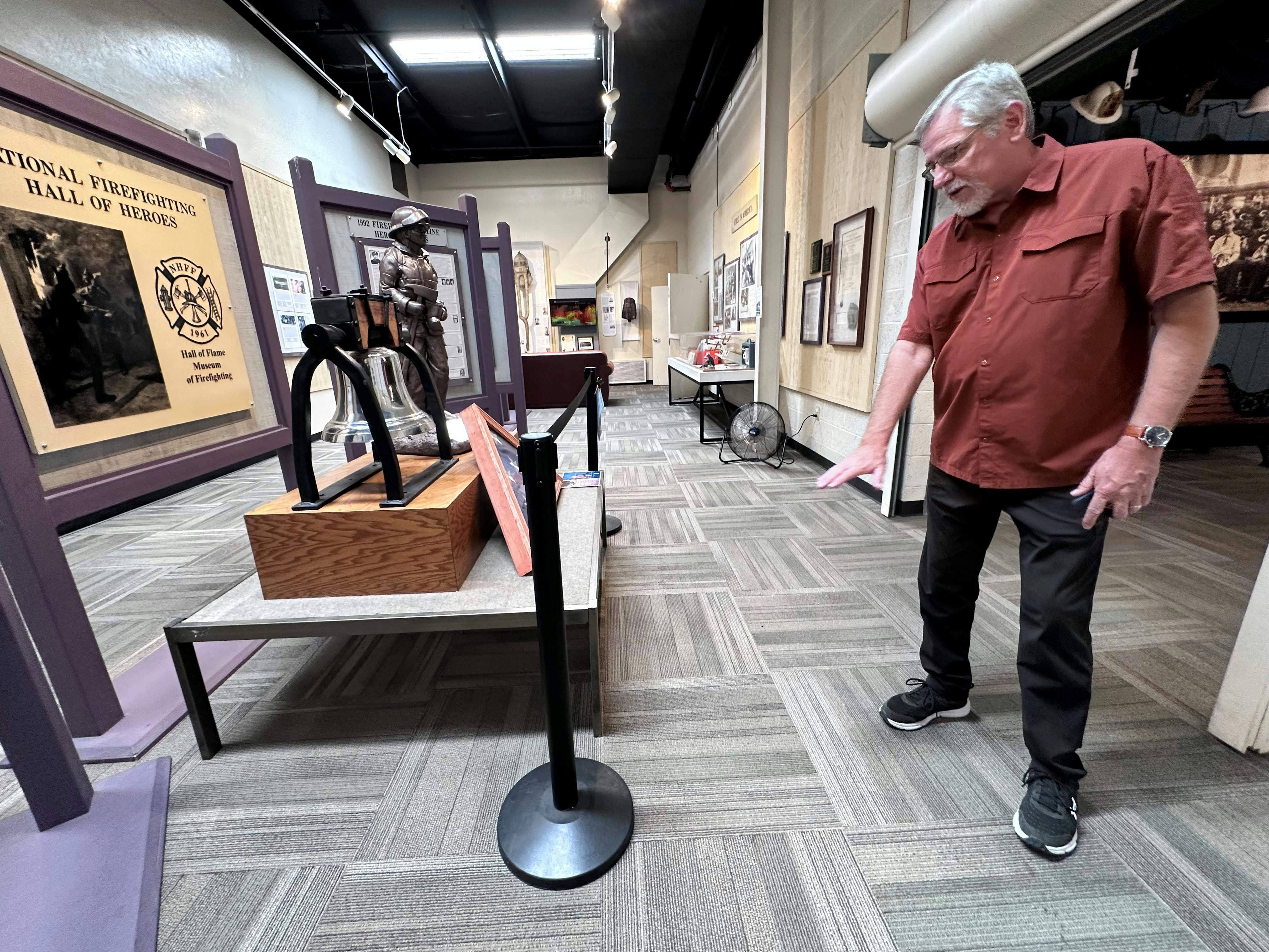 Hall of Flame Executive Director Chuck Montgomery shows points to where water damage the Hall of Heroes at the Phoenix fire museum following two storms.