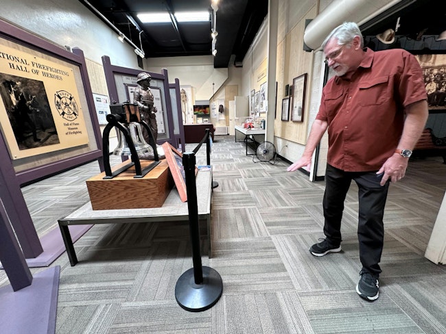 Hall of Flame Executive Director Chuck Montgomery shows points to where water damage the Hall of Heroes at the Phoenix fire museum following two storms.