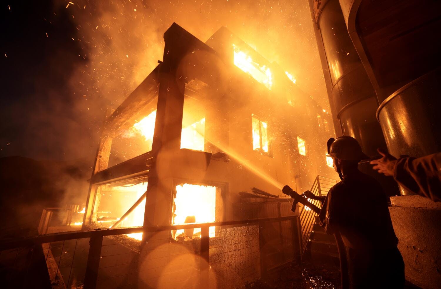A firefighter attempts to control a house fire in Palisades in January.