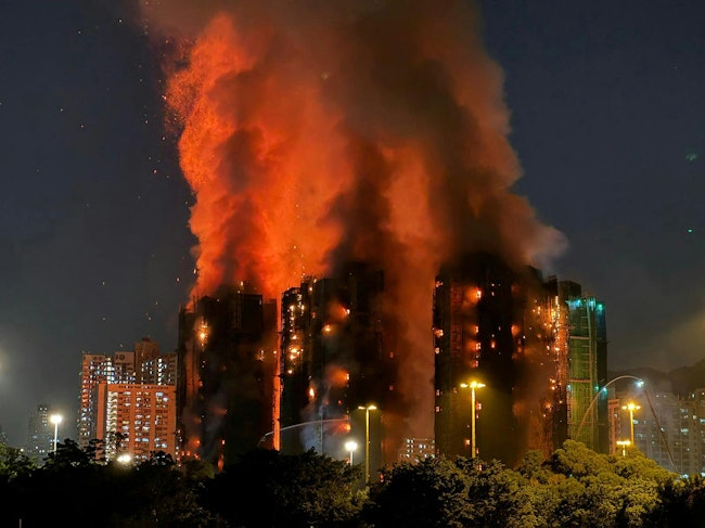 Thick smoke and flames rise as a major fire engulfs several apartment blocks at the Wang Fuk Court residential estate in Hong Kong's Tai Po district on Nov. 26, 2025. At least 36 people were killed when a fire engulfed several high-rise blocks in a Hong Kong residential estate on Nov. 26, the government said, with media reporting that some residents were trapped inside. (Yan Zhao/AFP via Getty Images/TNS)