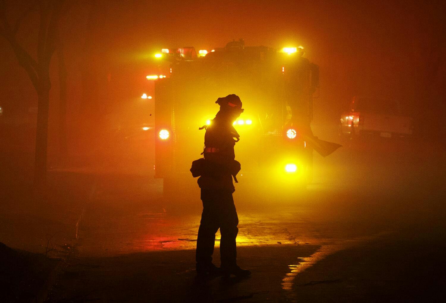 A firefighter walks on an Altadena Street in January.