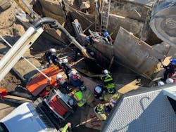Firefighters used the vacuum truck to remove debris from around the victim. Debris was removed below his waist before he was placed in a harness on a rope system from a tower ladder to be removed. Firefighters used the vacuum truck to remove debris from around the victim. Debris was removed below his waist before he was placed in a harness on a rope system from a tower ladder to be removed.