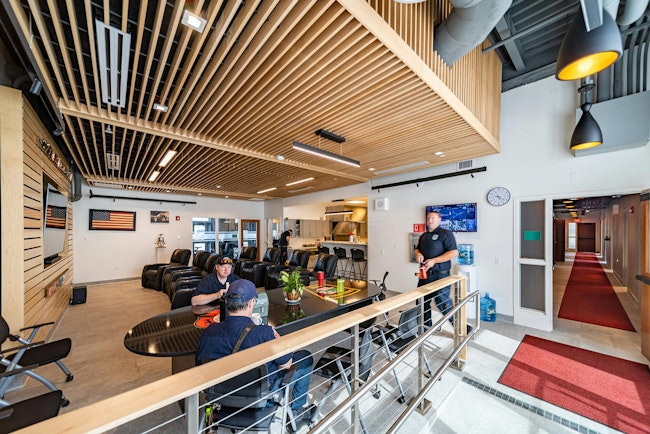 The new fire headquarters in Greenfield, MA, features an open-concept layout between the dayroom and kitchen, enhanced by warm wood tones, acoustic ceilings and wall panels.