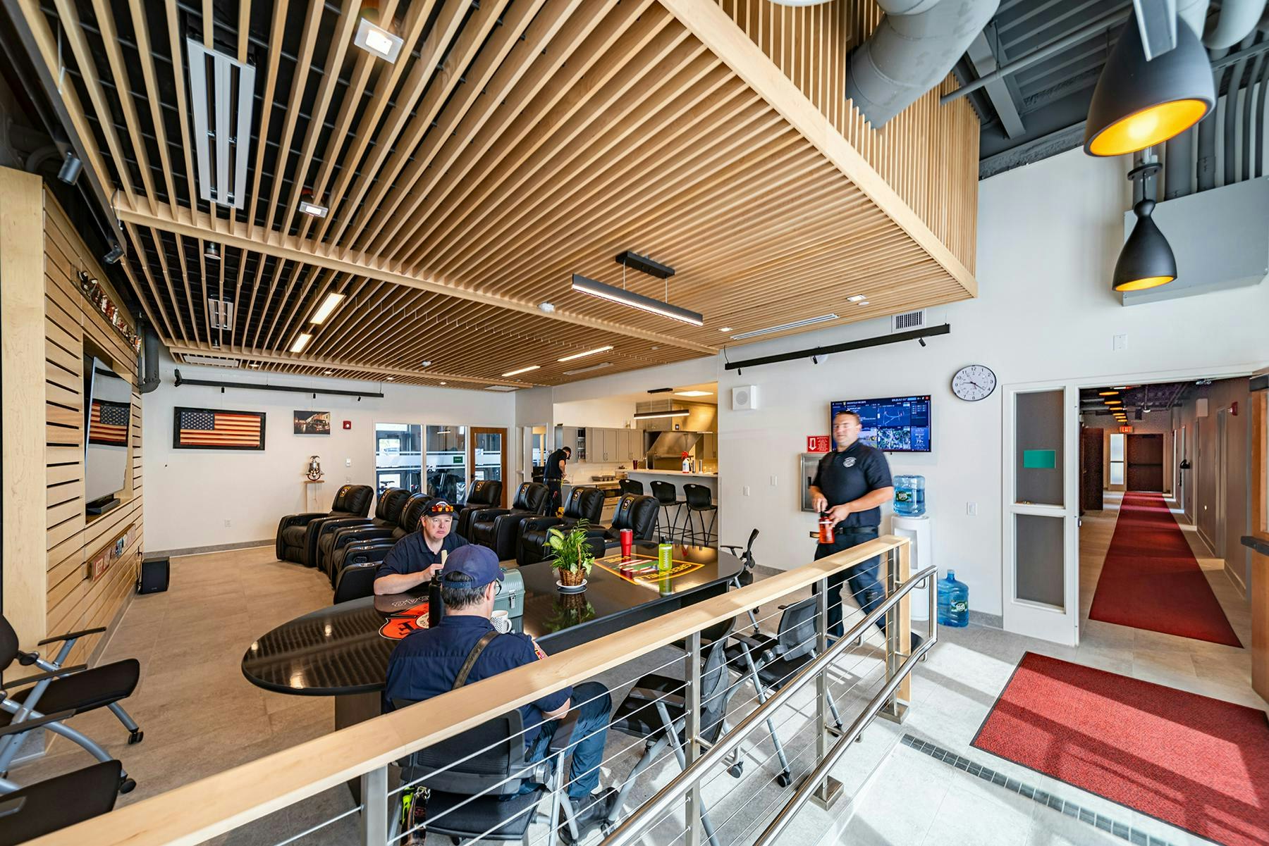 The new fire headquarters in Greenfield, MA, features an open-concept layout between the dayroom and kitchen, enhanced by warm wood tones, acoustic ceilings and wall panels.