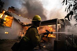 A firefighter tries to battle flames in January. A firefighter tries to battle flames in January.
