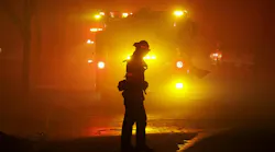 A firefighter turns as smoke is blown down on them while providing structure protection in Altadena, CA, on Jan. 7, 2025.