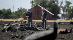 Fire investigators examine debris from the Devastating Pyrotechnics explosion in a nearby field in Esparto on July 21, 2025,