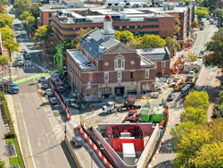 The renovation of the Cambridge, MA, Fire Department Headquarters had to comply with the city’s requirement that all nonresidential construction project had to be all-electric and Net Zero. A full substation had to be built on headquarters property (foreground). Instead of opting for the initial premise of the substation being wrapped in chain link fence, a decorative red steel enclosure that is reminiscent of the department’s response district was employed. The renovation of the Cambridge, MA, Fire Department Headquarters had to comply with the city’s requirement that all nonresidential construction project had to be all-electric and Net Zero. A full substation had to be built on headquarters property (foreground). Instead of opting for the initial premise of the substation being wrapped in chain link fence, a decorative red steel enclosure that is reminiscent of the department’s response district was employed.