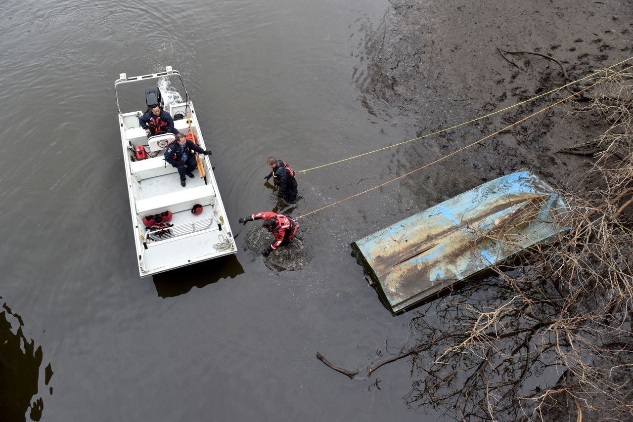 firefighters conducting a search at edge of a body of water