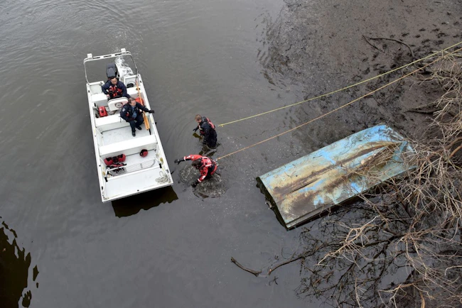firefighters conducting a search at edge of a body of water