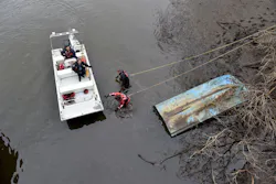 firefighters conducting a search at edge of a body of water firefighters conducting a search at edge of a body of water