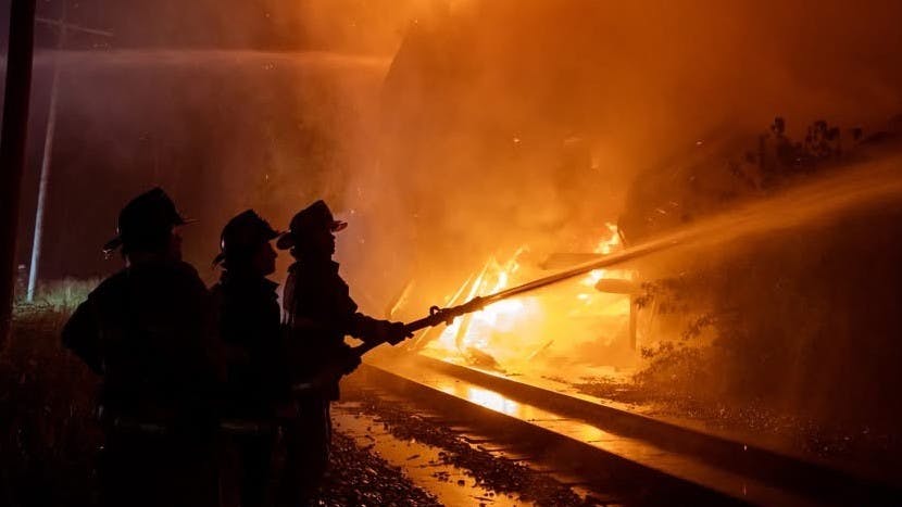 firefighters operating hoseline at fire