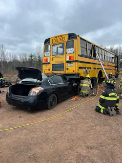 firefighters training scenario involving school bus on top of automobile