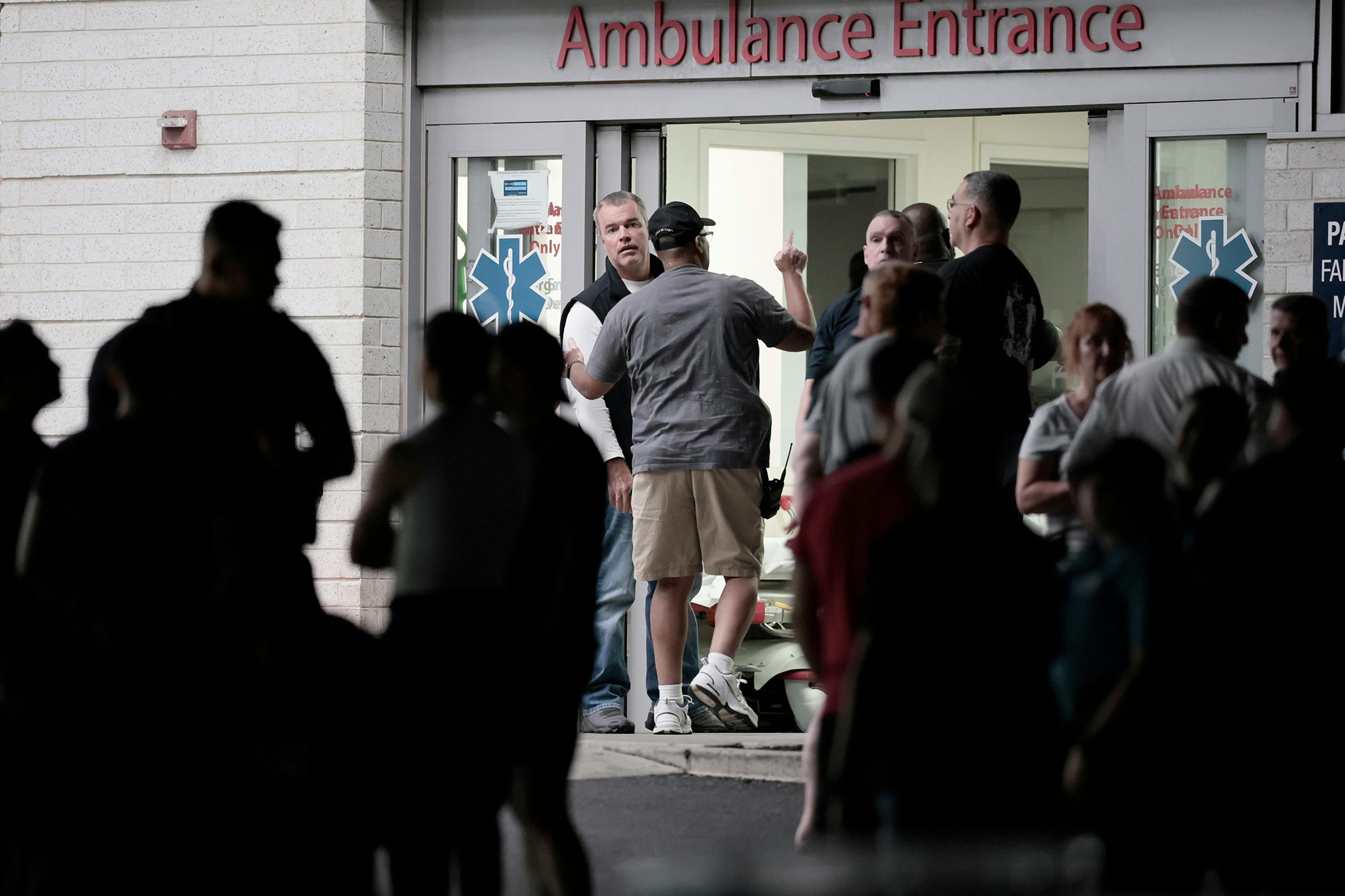 Philadelphia officials gather at the entrance of Penn Presbyterian Medical Center, where three Philadelphia police officers were taken after being shot by a retired firefighter.