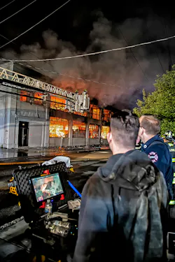 firefighters considering images captured by a drone at a warehouse fire to aid in tactical decisions