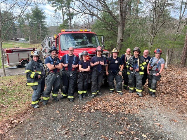 fire department members standing in front of a fire vehicle