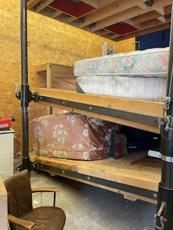 training prop of structural building collapse with upper floor slanted and resting on a manikin