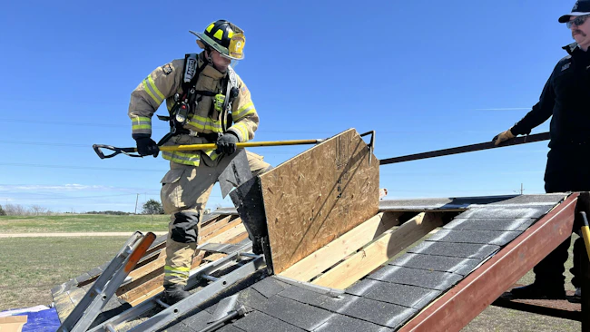 probationary firefighter being trained by officer on roof operations propr
