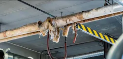 Asbestos covering on pipes is broken, allowing debris to travel through the living spaces inside fire stations.