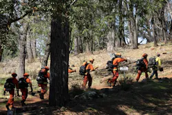 Inmates walk to a training area to cut logs at the Growlersburg Conservation Camp near Georgetown.