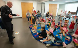fire department chief speaking with children at an elementary school even