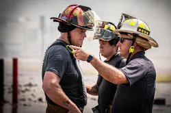 fire department chief at a drill for firefighters conversing with a company officer