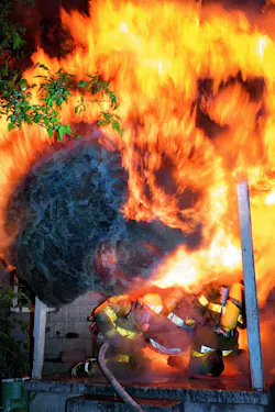firefighters at front door of house as flashover occurs