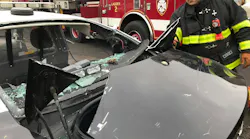 firefighter examining crashed police vehicle regarding occupant extrication