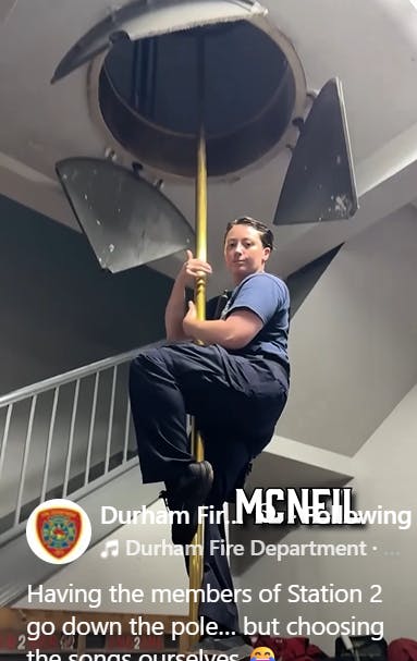 A Durham firefighter slides down a pole in a firehouse.