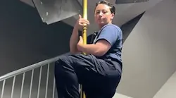 A Durham firefighter slides down a pole in a firehouse.