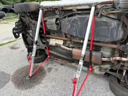 In this instance in which two R.A.V.E Struts are deployed on the underside of a vehicle, the ratchet strap's built-in sliding heat shield is visible on the right strap in place against the vehicle's muffler.