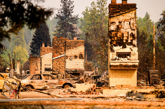Chimneys remain where houses once stood in a residential community during the Old Trails fire in Spokane.