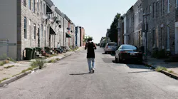 A man walks down a Baltimore street near where a person was murdered on July 28, 2019.