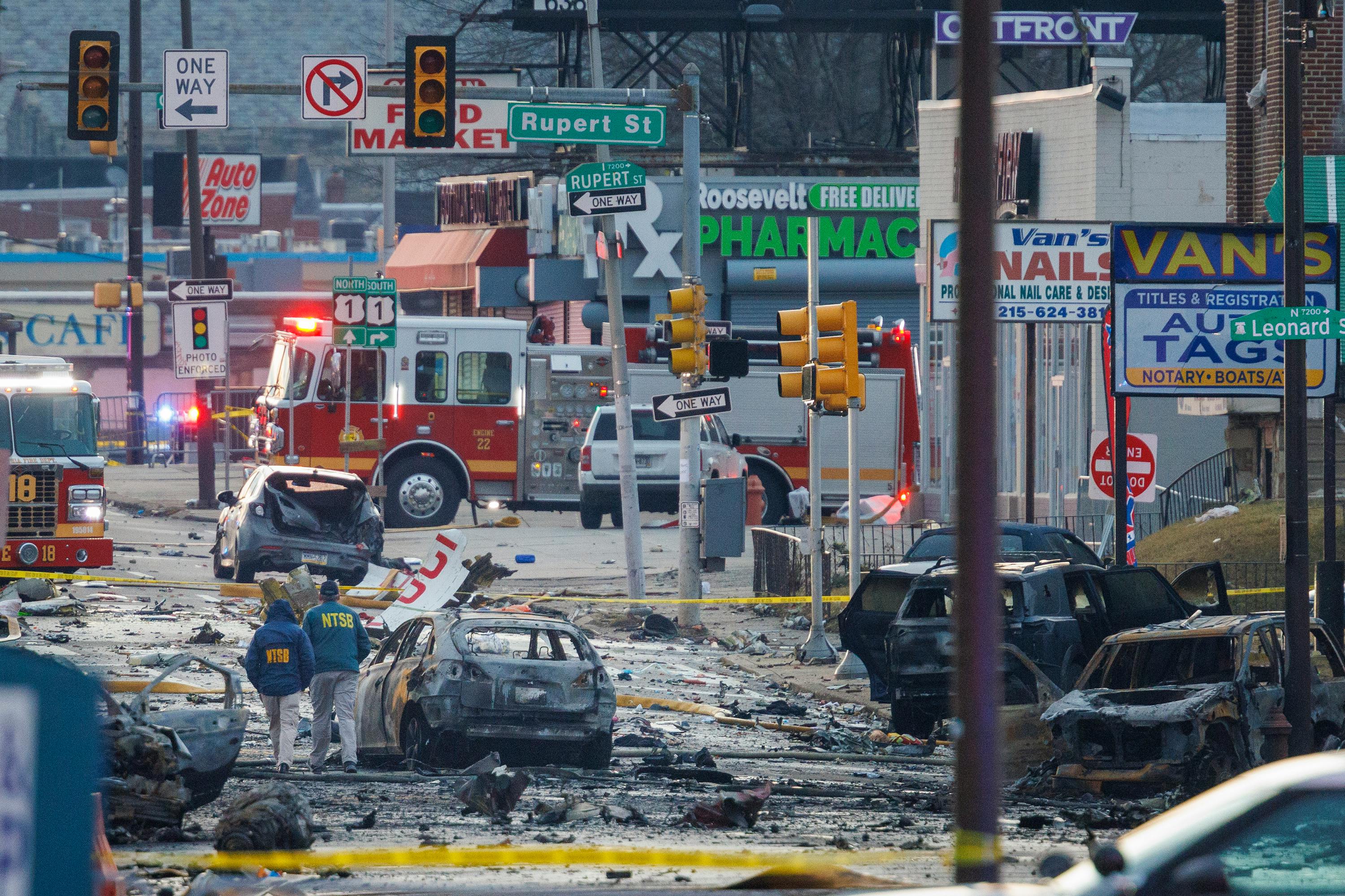 Charred debris littered the street following the crash of a medical jet that killed six people aboard and two on the ground.