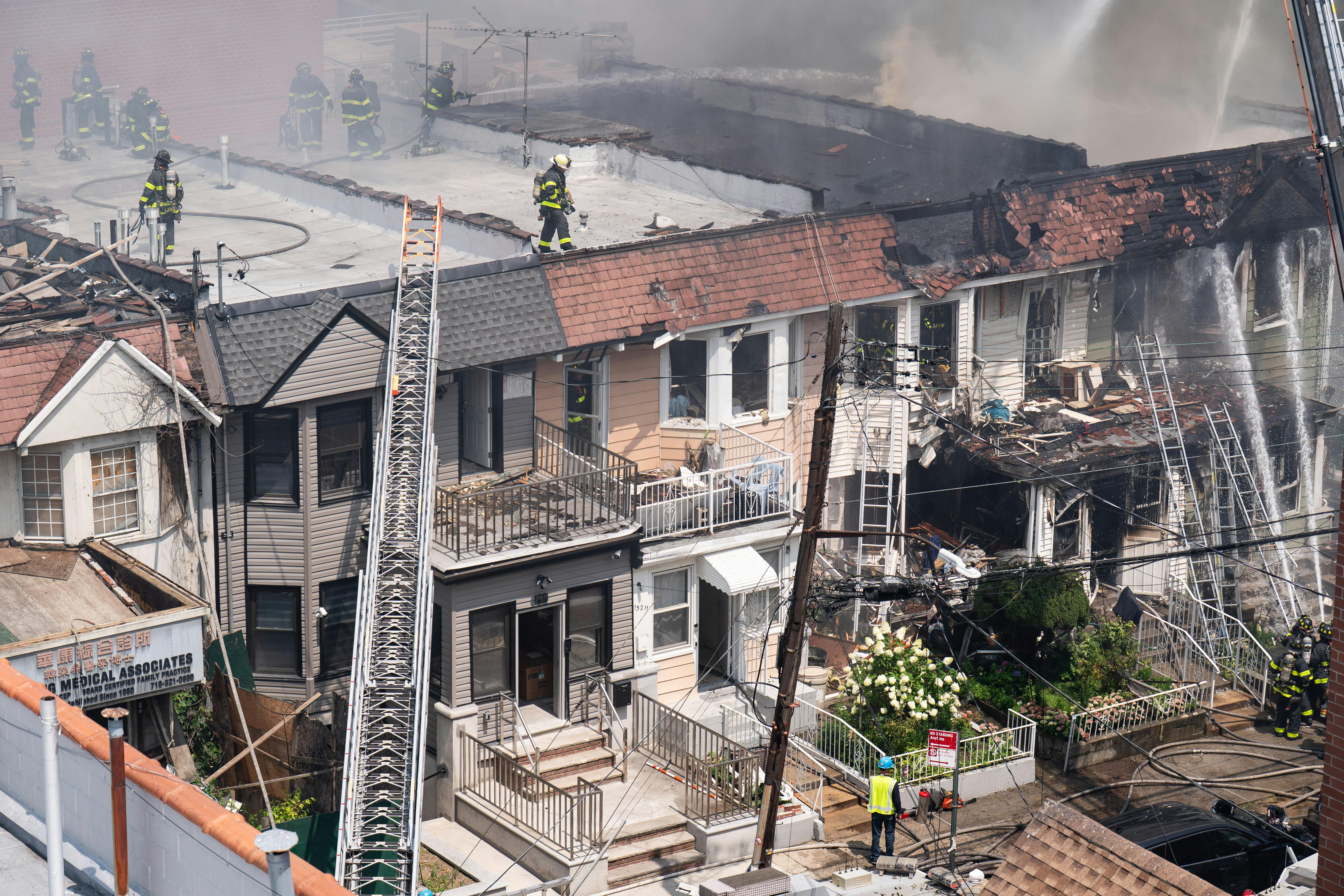 A 78-year-old woman died and 22 other people, including more than a dozen firefighters, were injured after a massive fire ripped through a Queens home on College Point Blvd. near 41st Rd. in Flushing, Queens on Saturday, July 25, 2026, before spreading to two adjoining buildings.