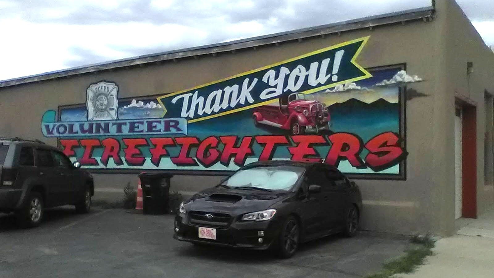 exterior wall of commercial building painted with a mural thanking volunteer firefighters