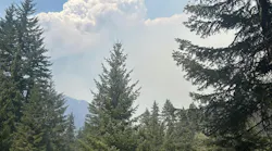 A smoke column rises from the northwest edge of the Little Giant Fire.