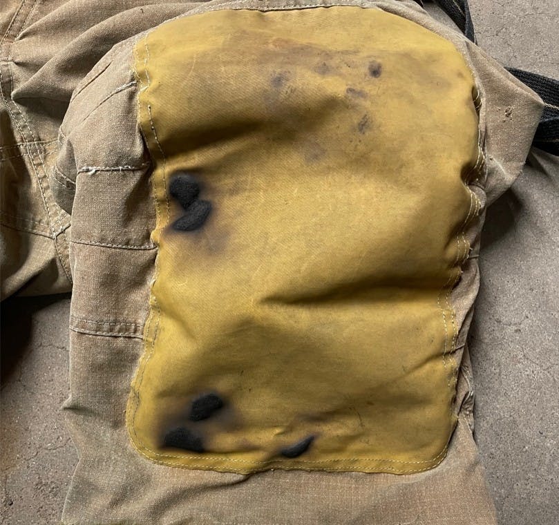 burned knee pads of firefighter who knelt on hot embers during a training