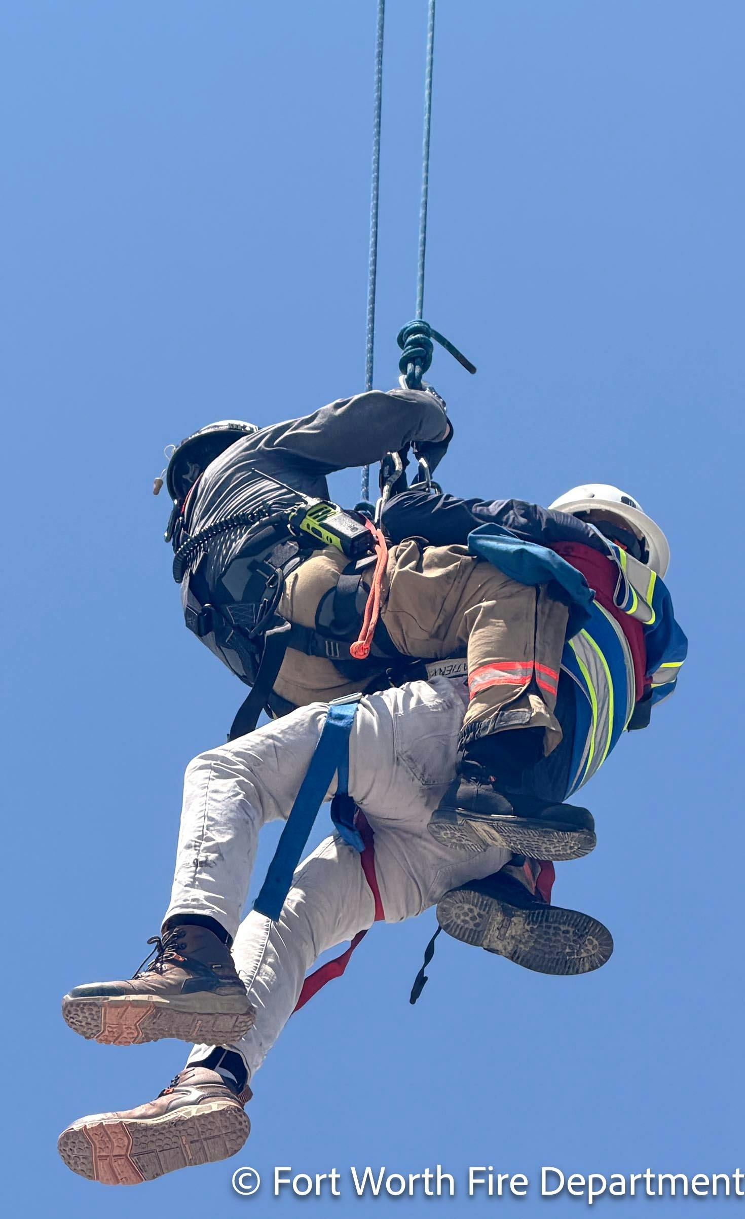 A crane operator is brought to the ground by a Fort Worth rescue technician.