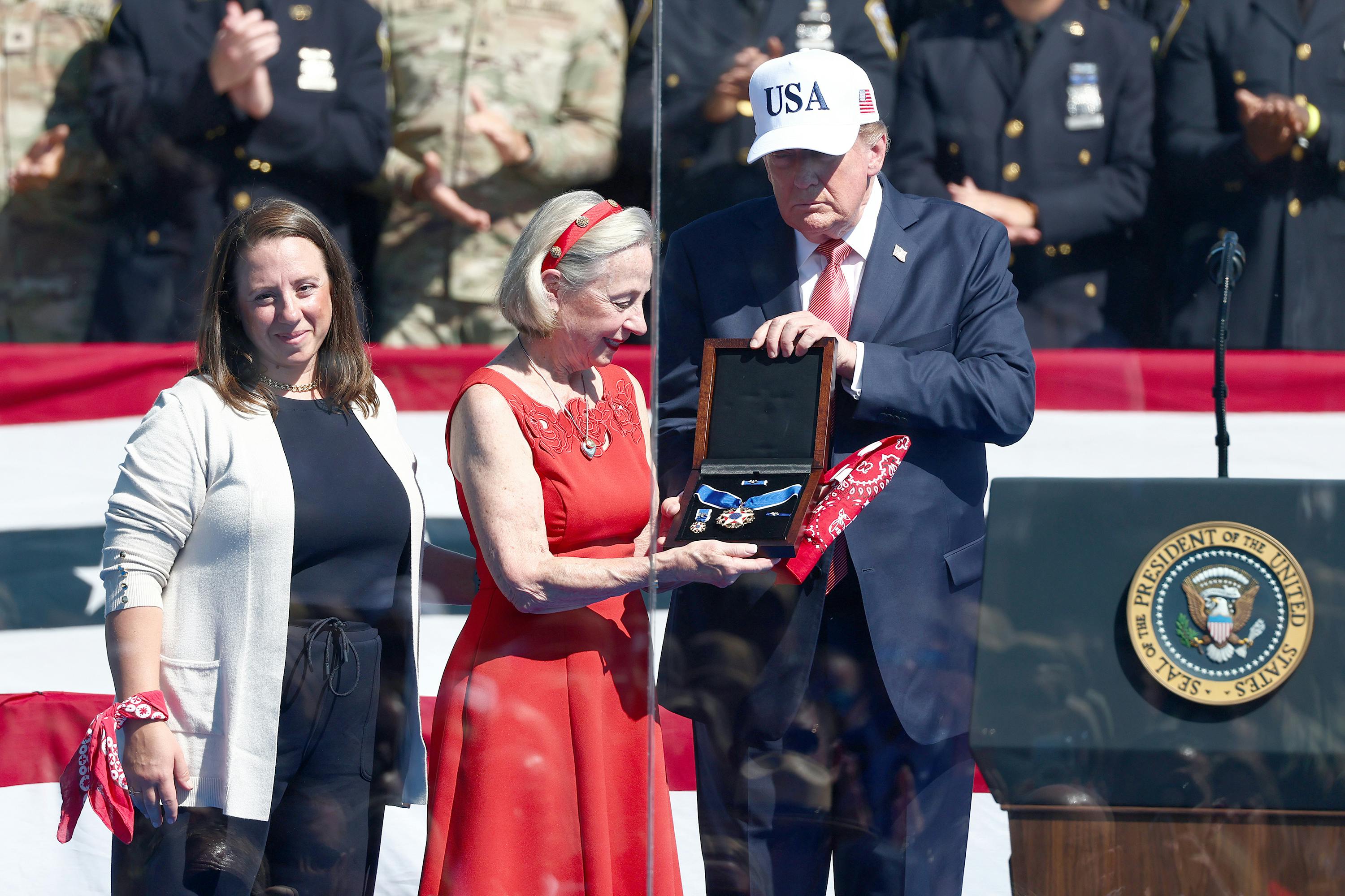President Donald Trump presented the Presidential Medal of Freedom to Allison Crother, the mother of volunteer firefighter, also known as the 'man in the red bandana' Welles Crother, who died after saving 18 stranger in the World Trade Center on Sept. 11. His sister, Paige, is at left.
