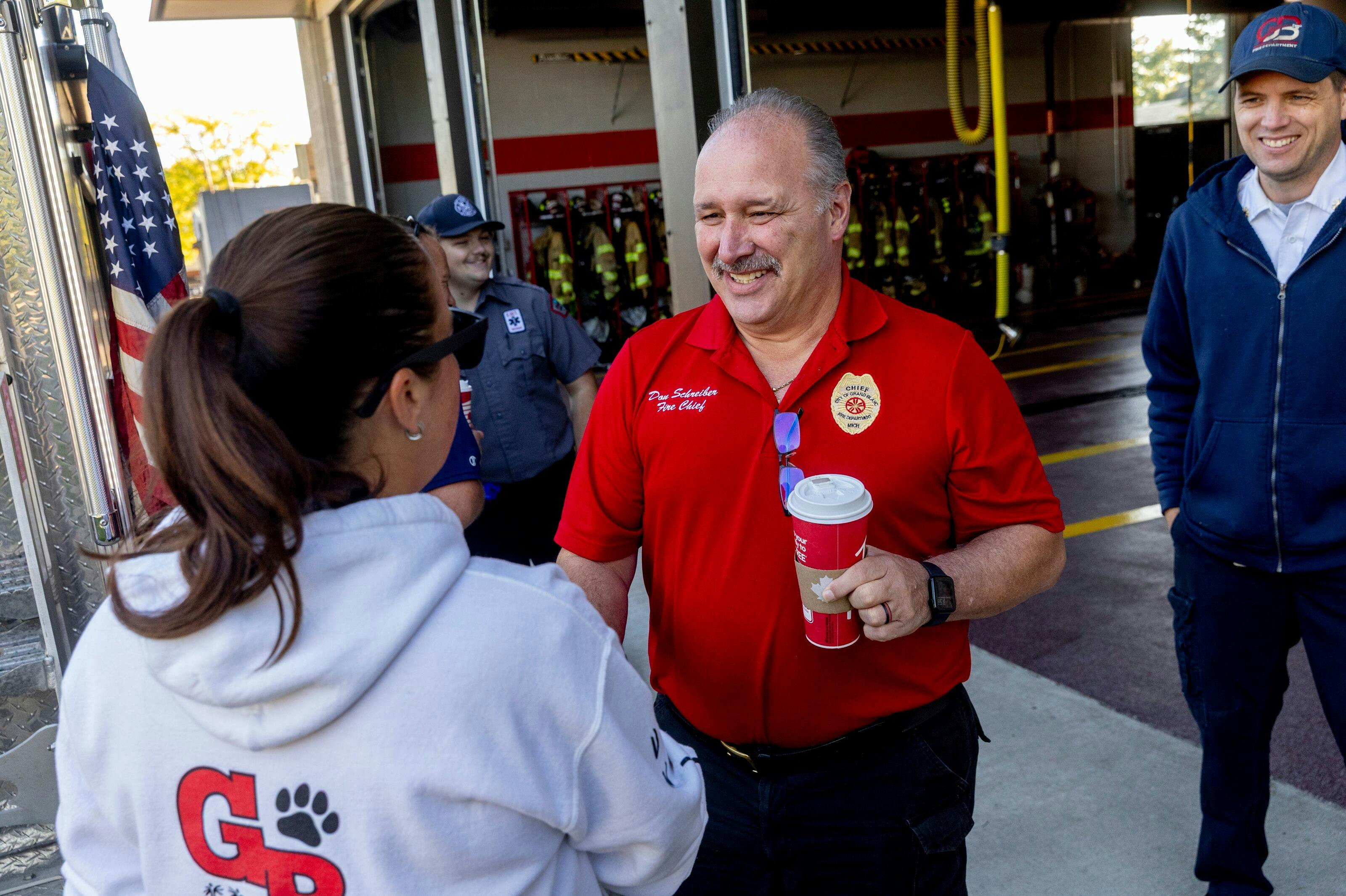 Grand Blanc Fire Chief Don Schreiber II thanks a student for the gift bags she and her classmates delivered to the firehouse.