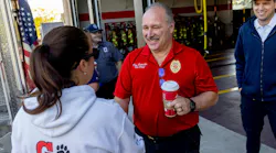 Grand Blanc Fire Chief Don Schreiber II thanks a student for the gift bags she and her classmates delivered to the firehouse.