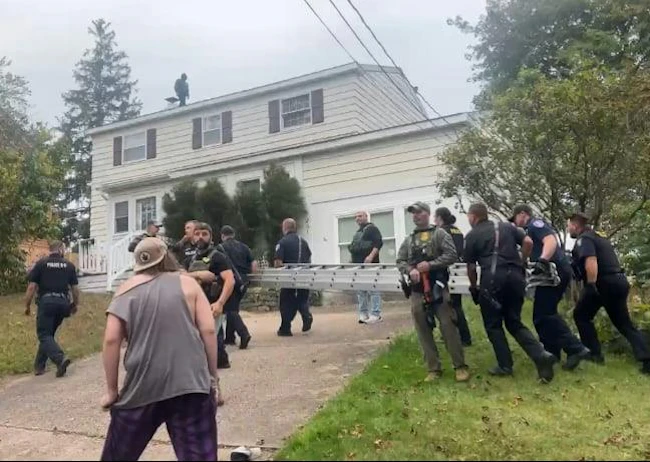 Oswego firefighters and police officers carried a ladder at the request of the U.S. Customs and Border Patrol after two men scurried to the roof during a recent encounter.