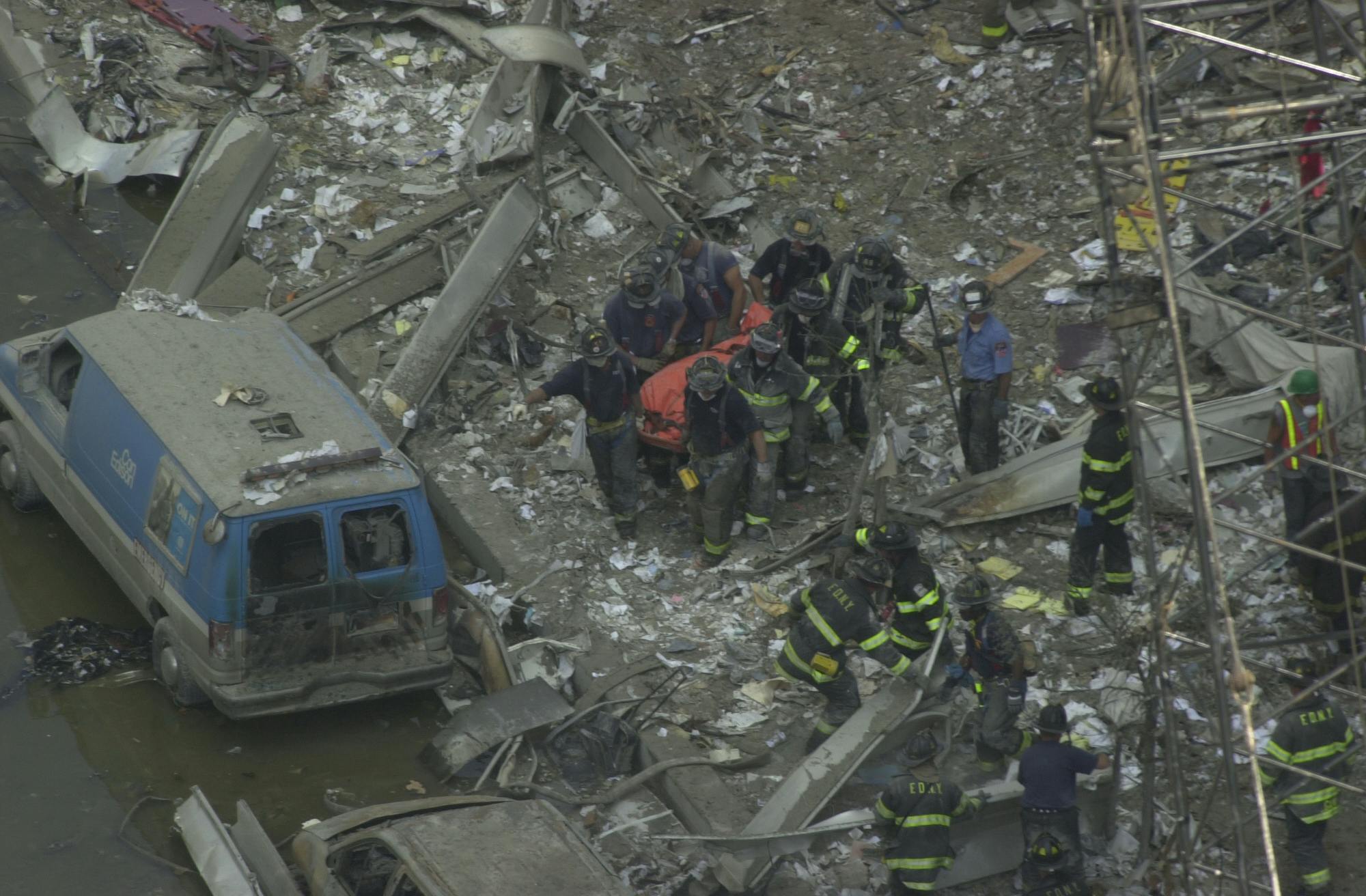 Firefighters carry a body from the rubble of the World Trade Center.