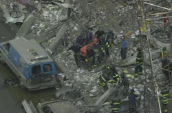 Firefighters carry a body from the rubble of the World Trade Center.